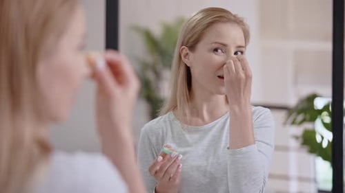Woman Applying Makeup with Sponge at Home