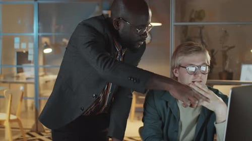 Male Colleagues Discussing Project on Computer in Night Office