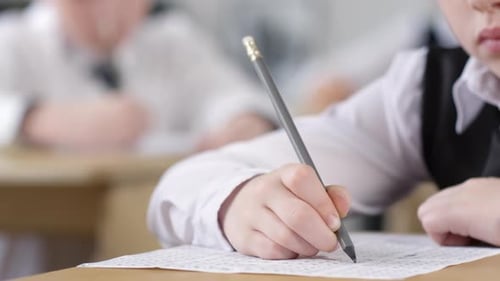 Unrecognizable Schoolgirl Filling Out Test Answer Sheet