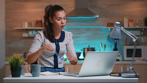Woman Working on Laptop at Kitchen Counter
