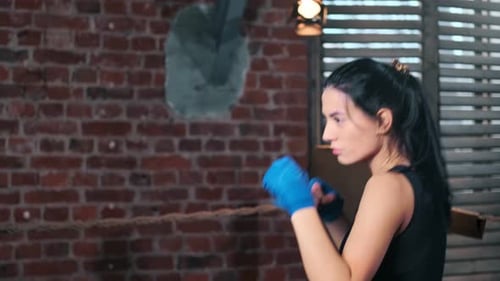 Powerful Woman Boxer Training with Heavy Bag