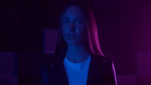 Stylish Young Woman Poses in Blue and Pink Light