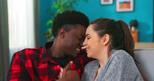 Loving Couple Holding Hands on Couch Indoors