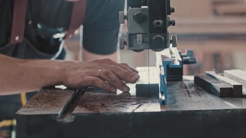 Carpentry Works Worker Slowly Cutting Along the Wooden Detail with an Automatic Saw