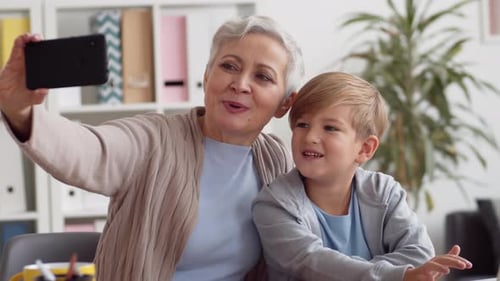 Grandmother and Grandson Taking a Selfie Indoors
