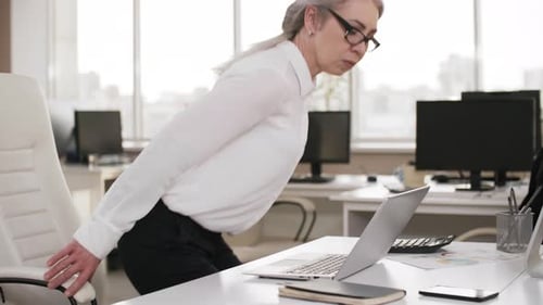 Middle-Aged Female Lawyer Working Overtime Alone in Office