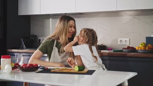 Child Plays with Young Mom in Kitchen