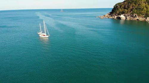 Boat Near Tropical Shore. Amazing Drone View of Modern Yacht Sailing on Calm Sea Water Near Coast