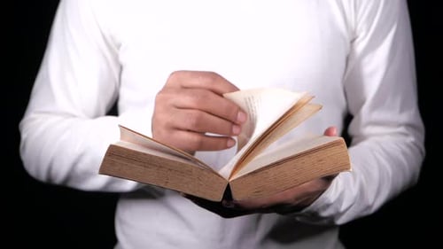Fingers Turn Pages of Worn Old Book