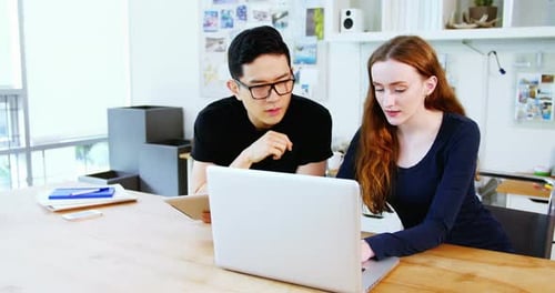 Team Collaboration on Laptop in Bright Office Setting