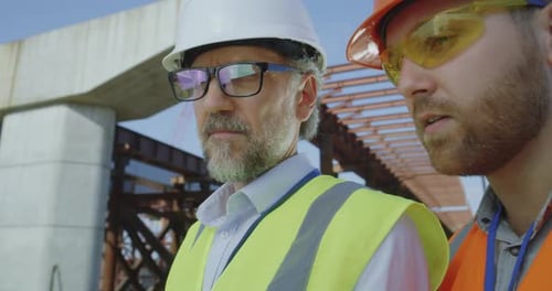 Construction Workers Discussing Plans on Construction Site