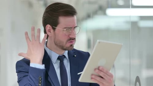 Man With Tablet Expressing Confusion