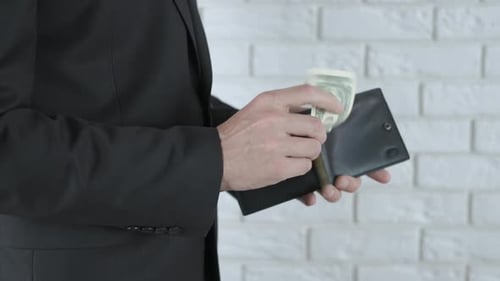 Man in Suit Counting One Dollar Bills