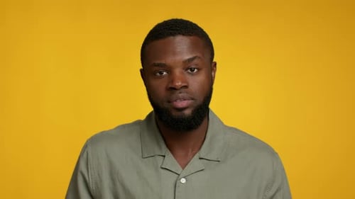 Serious Man with Beard Portrait on Yellow Background