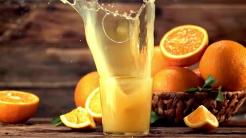 Orange Slice Splashing into Glass of Fresh Juice