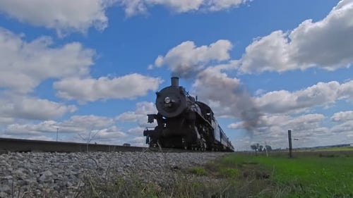 A Ground View of An Antique Steam Passenger Train Approaching and Going By on a Beautiful Sunny Day