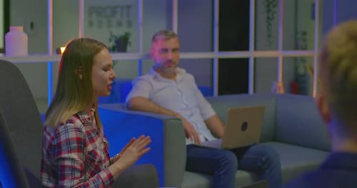 Jeune pigiste parle à des partenaires, elle est souriante et gesticulaire