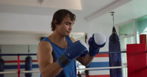 Caucasian man boxing in boxing gym