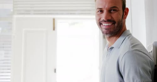 Man Smiling Using Tablet Device Indoors Brightly Lit