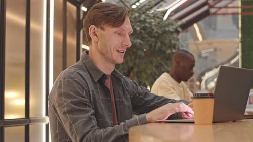 Kaukasischer Mann arbeitet im Café am Laptop