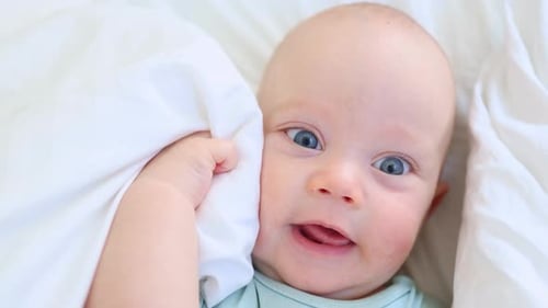 Cute Infant Smiling on White Blanket