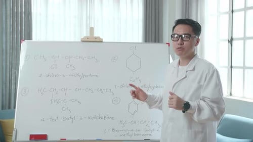 Adult Explaining Chemistry Formulas on Whiteboard