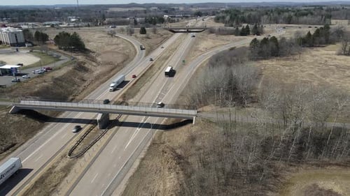 Luftbild der Autobahnkreuzung mit Fußgängerbrücke und Autobahnbrücke an einem hellen Herbsttag.