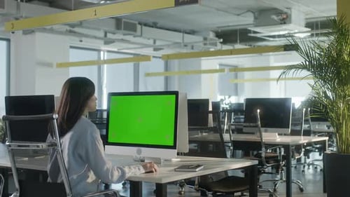Business Multiethnic Woman Working on Desktop Computer with Green Screen Mock Up Display in Busy