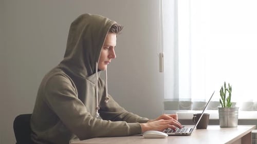 Junger Hacker konzentriert sich auf Codierung, Hacker schaut auf Screen Monitoring Stock Online