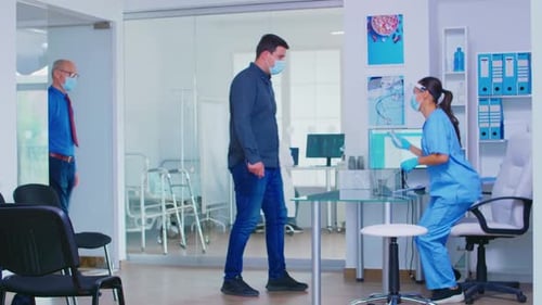 Nurse Takes Patient's Temperature in Medical Office