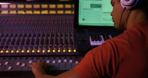 Male sound engineer working at a mixing desk