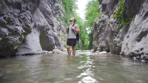 Young man in the creek between the rocks.