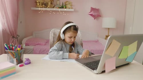 Young Girl Studies at Desk in Bedroom