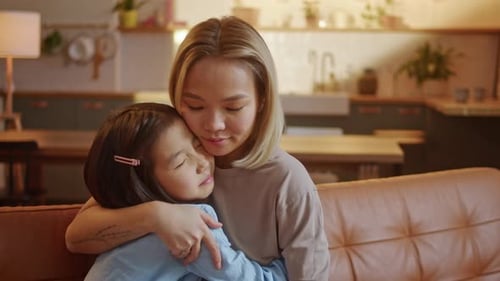 Loving Mother and Child Cuddle on Couch