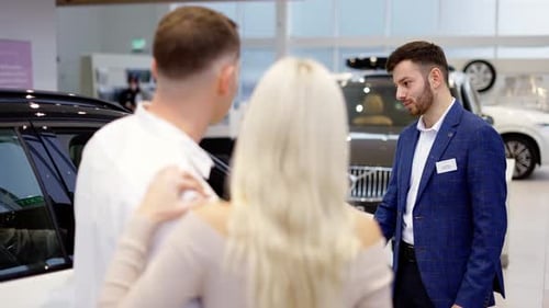 Footage From the Back Couple Talking to Car Dealer in Dealership Discussing the Chosen Car