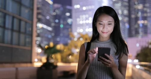 Woman Using Smartphone at Night in the City