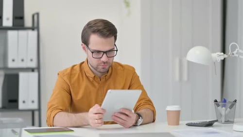 Man Frustrated with Tablet in Office Workplace