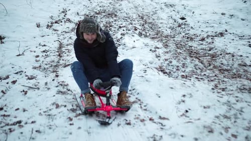 Young Man Goes Sledding in Winter