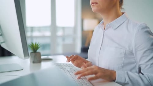 Woman Typing on a Computer Keyboard at Desk