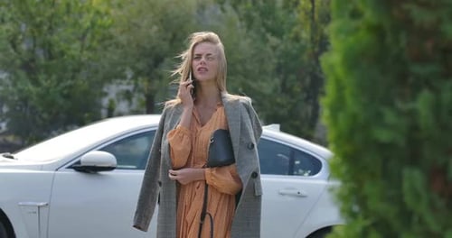 Fashionable Woman Talking on Phone Near Car