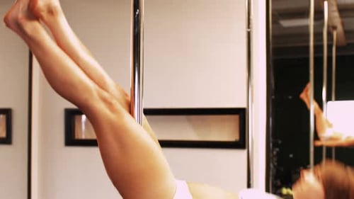 Woman Doing Pole Dancing Exercise in Studio