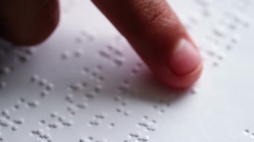 Estudante lendo um livro em Braille na sala de aula na escola