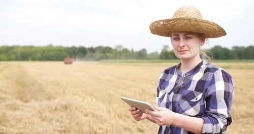 Young Adult with Tablet in Harvested Rural Field