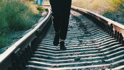 Junge schöne Frau geht alleine auf der Bahnstrecke