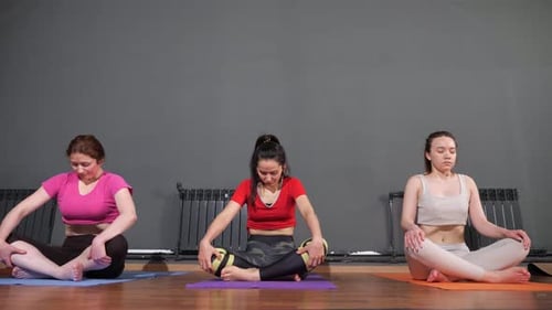 Women Meditating Indoors in Cross Legged Position
