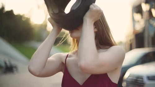Beautiful Woman Putting on Motorcycle Helmet in City