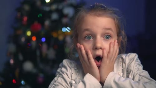 Shocked Girl In Front of a Christmas Tree