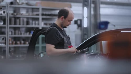 Mechanic Using A Digital Tablet to Search for Approval and Diagnose Car Breakdowns