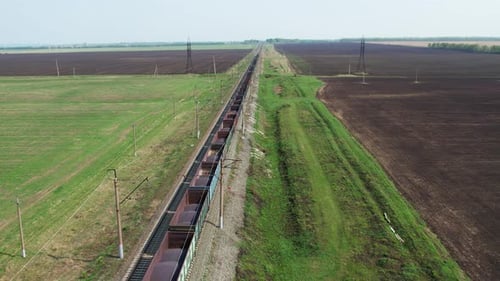 Freight Train Traveling Through Rural Landscape Aerial View