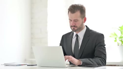 Young Businessman Working on Laptop in Office